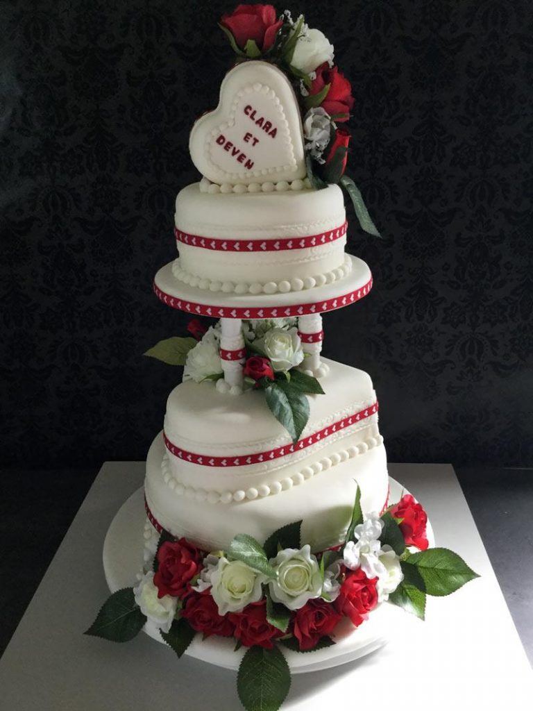 Gâteau de mariage blanc et rouge avec fleurs décoratives