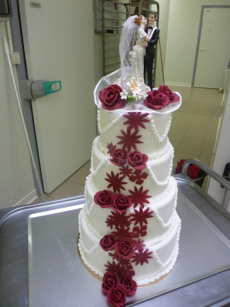 Gâteau de mariage blanc à étages orné de roses rouges