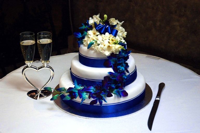 Gâteau de mariage bleu et blanc décoré de fleurs
