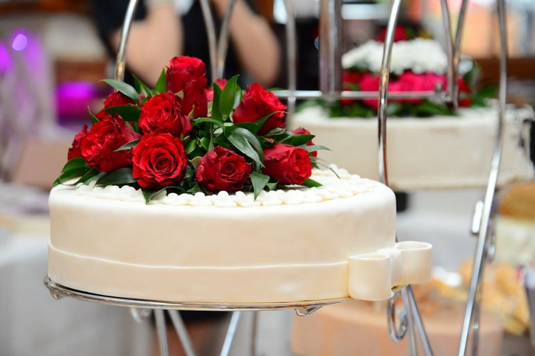 Gâteau blanc élégant avec roses rouges fraîches